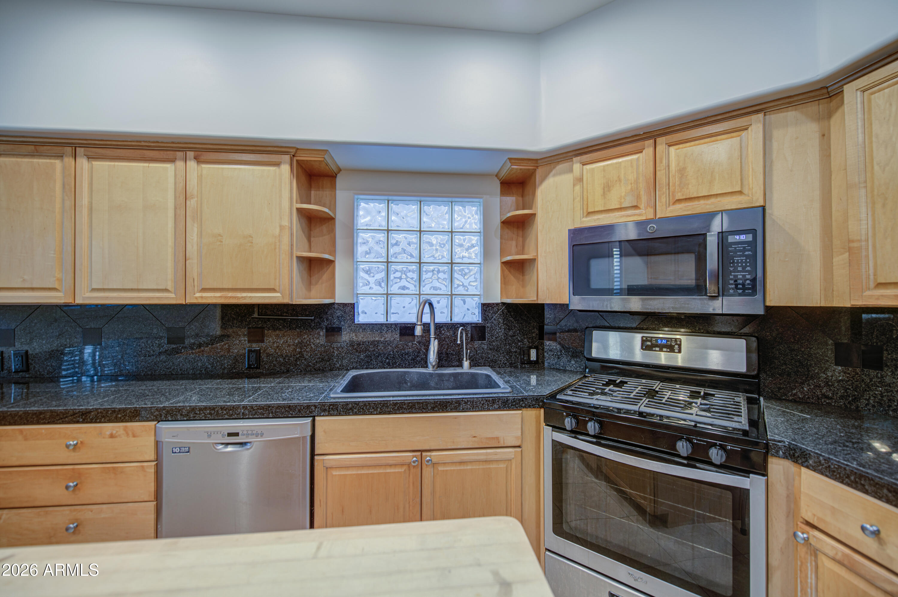 6018 North 5th Place Phoenix, AZ 85014 - Photo 19 of 53 a kitchen with stainless steel appliances granite countertop a stove a sink and a microwave