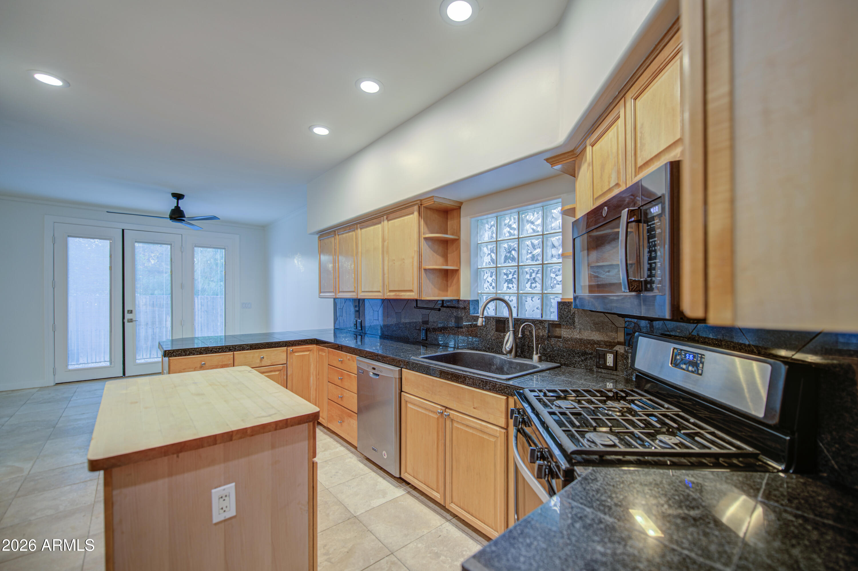 6018 North 5th Place Phoenix, AZ 85014 - Photo 20 of 53 a kitchen with stainless steel appliances granite countertop a sink stove and cabinets