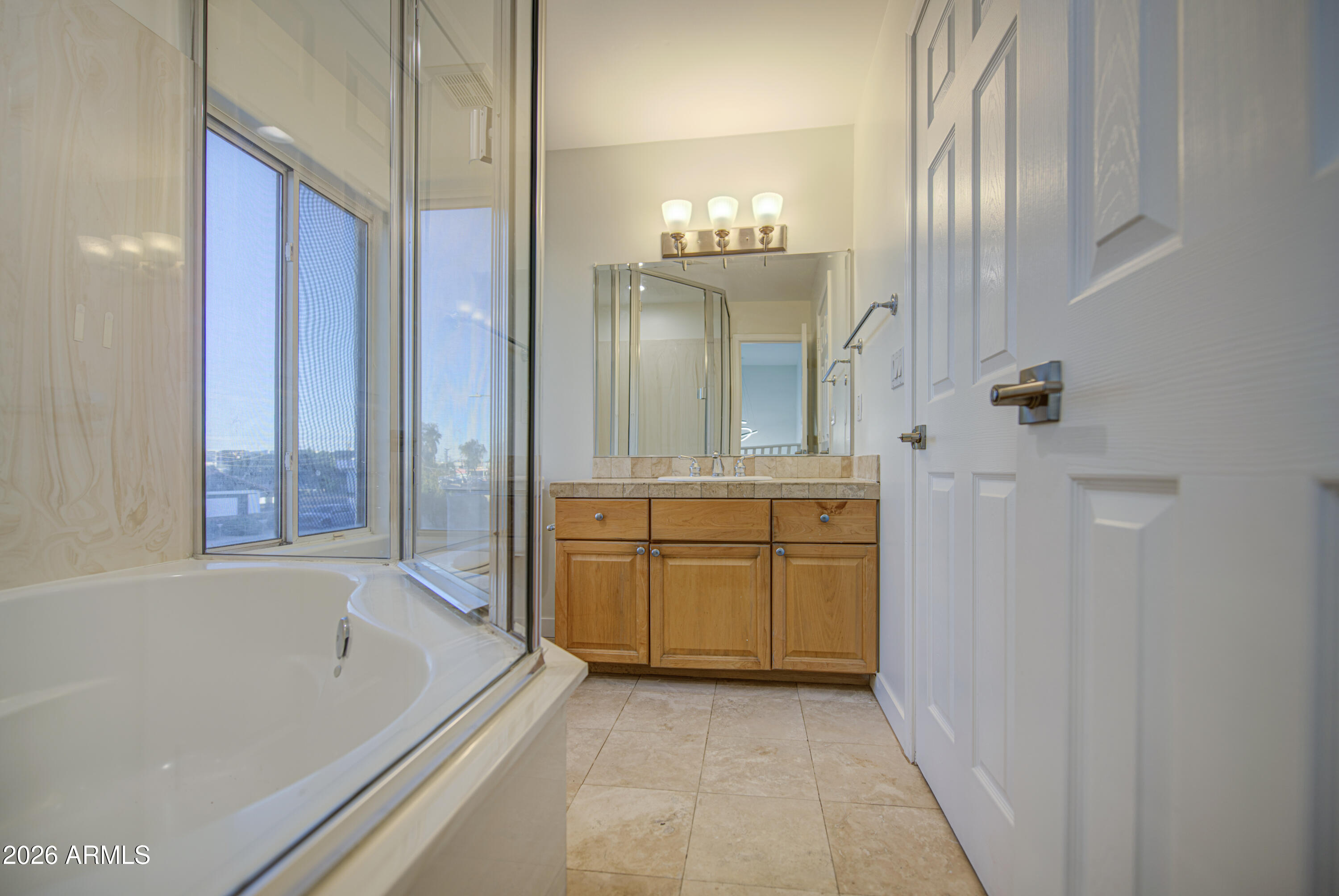 6018 North 5th Place Phoenix, AZ 85014 - Photo 36 of 53 a bathroom with a granite countertop sink a mirror and a bathtub
