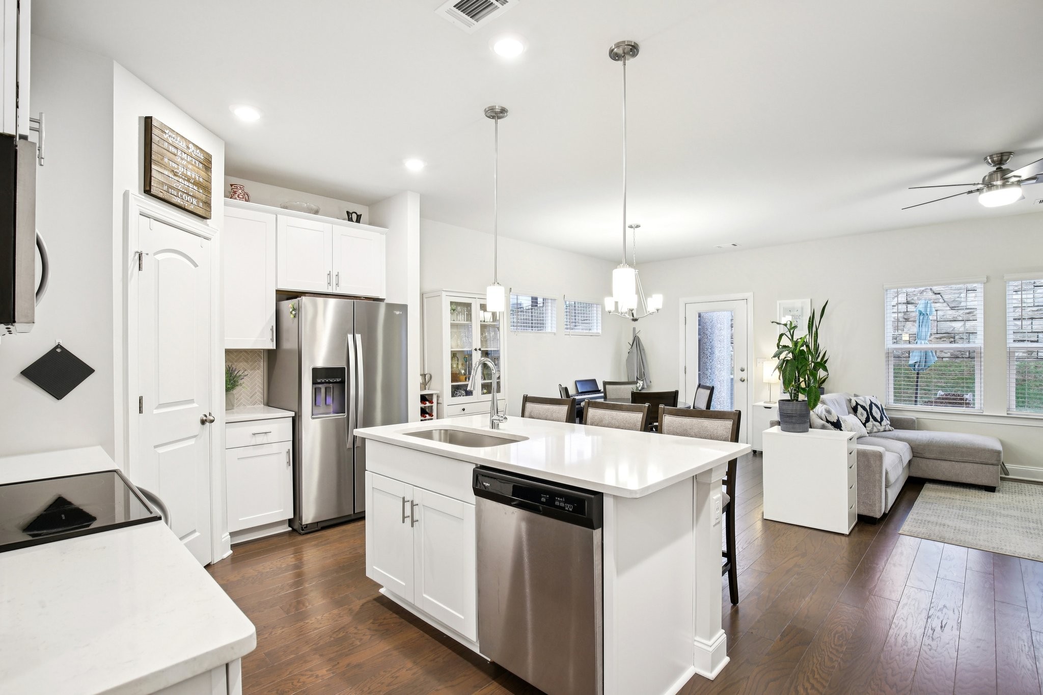 a kitchen that has a lot of white cabinets and stainless steel appliances
