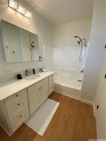a bathroom with a tub sink and mirror