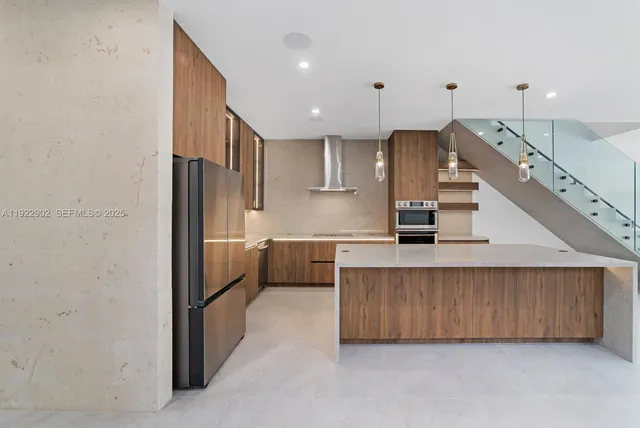 a kitchen with stainless steel appliances kitchen island granite countertop a refrigerator and a sink