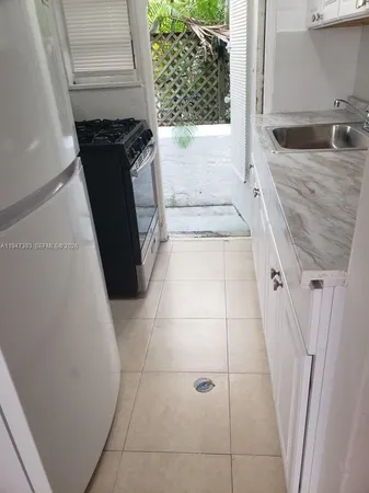 a bathroom with a granite countertop sink and a washing machine