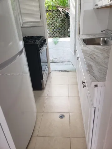 a bathroom with a granite countertop sink and a washing machine