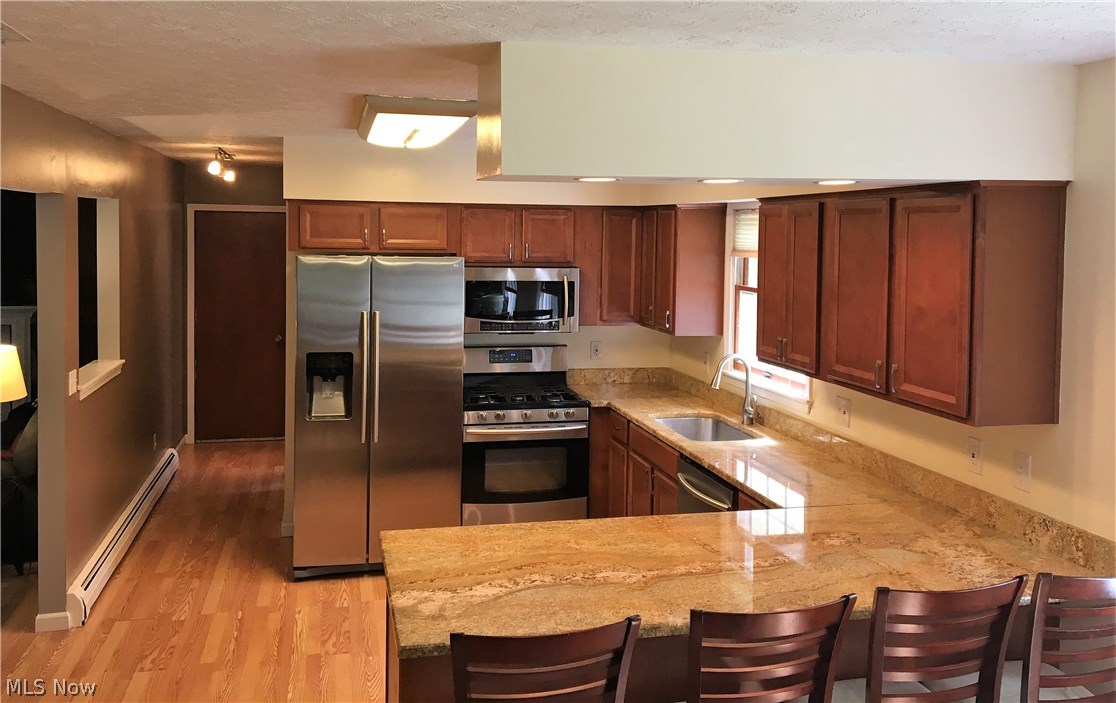Spacious kitchen with granite counter-tops, breakfast bar, and newer stainless appliances.