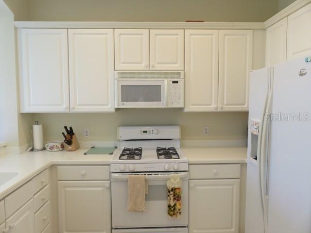 9720 Sea Turtle Terrace, Unit 201 Bradenton, FL 34212 - Photo 2 of 29 a kitchen with stainless steel appliances granite countertop white cabinets and a refrigerator