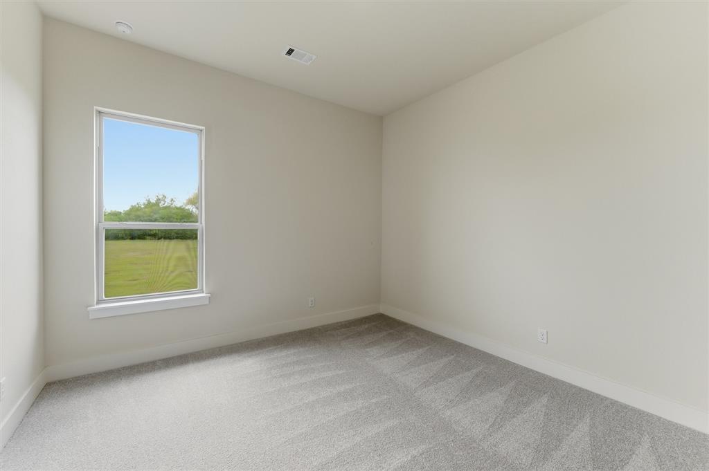 2433 Meteor Drive Krum, TX 76249 - Photo 22 of 29 Bright room featuring neutral wall paint, light gray patterned carpet, and a large window with white trim