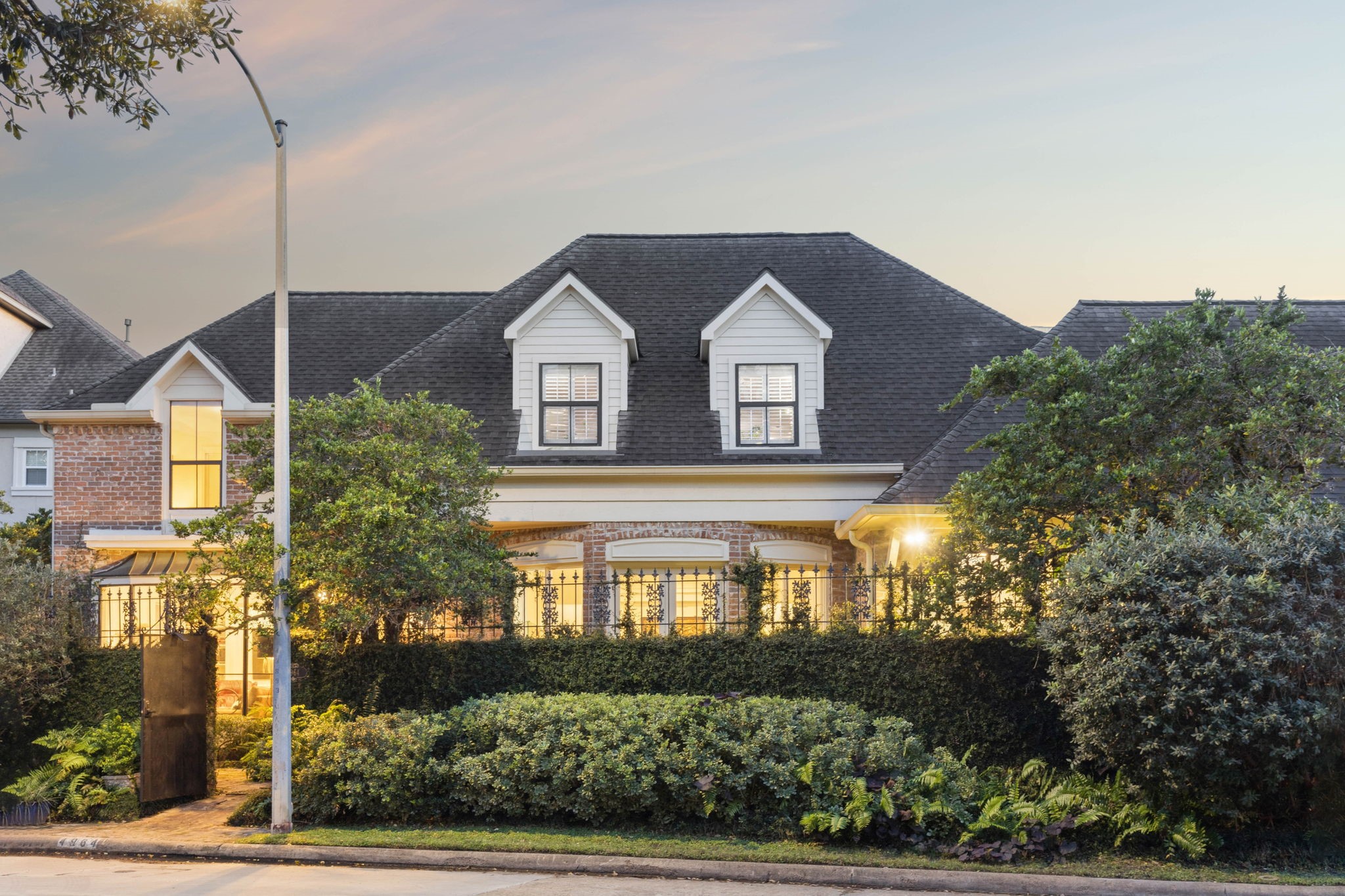 Warm exterior lighting, manicured hedges, and timeless architectural details create an understated yet elegant presence in a well-established neighborhood.  A perfect blend of privacy, character and street appeal.