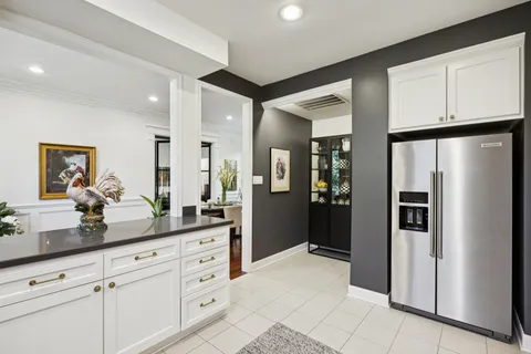 a kitchen with white cabinets and refrigerator