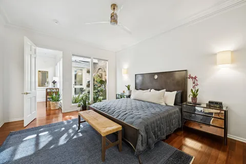 a bedroom with a bed and wooden floor