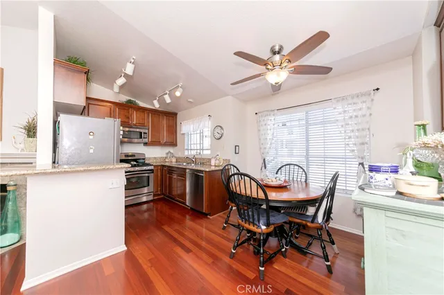 a kitchen with a dining table chairs and refrigerator