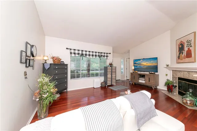 a living room with furniture a fireplace and wooden floor
