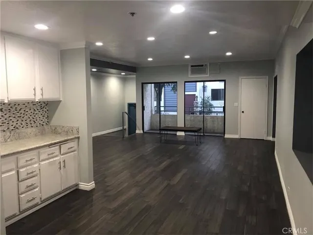 a view of a kitchen with furniture and wooden floor