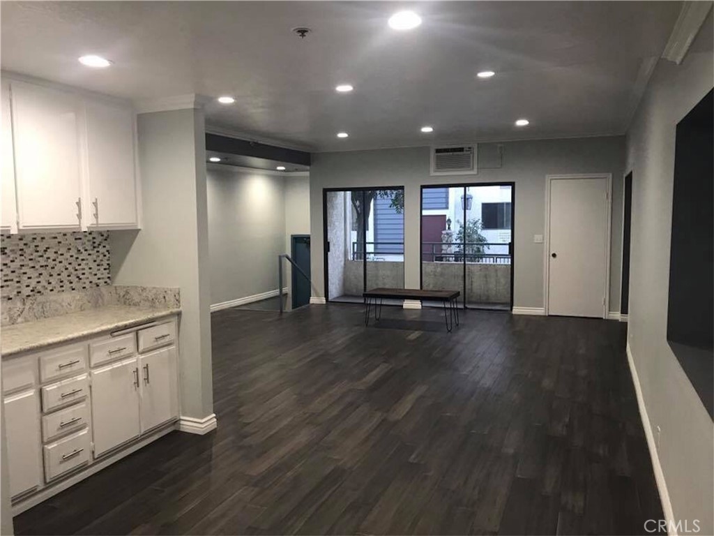 a view of a kitchen with furniture and wooden floor