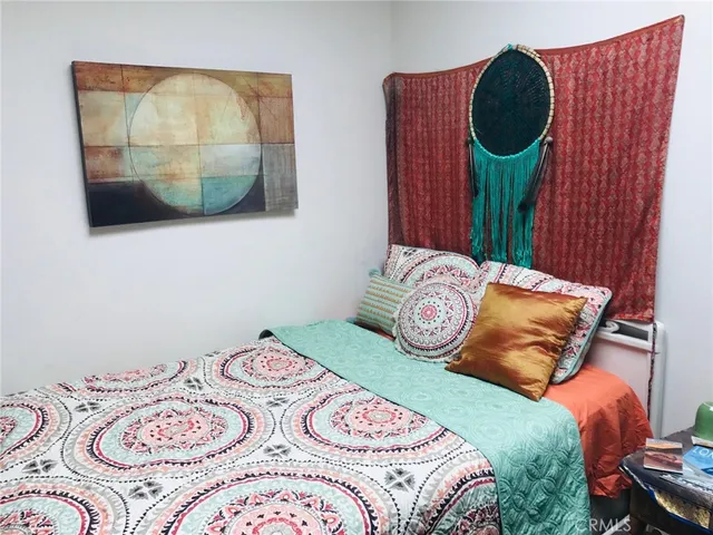 a bedroom with a bed and a painting on the wall