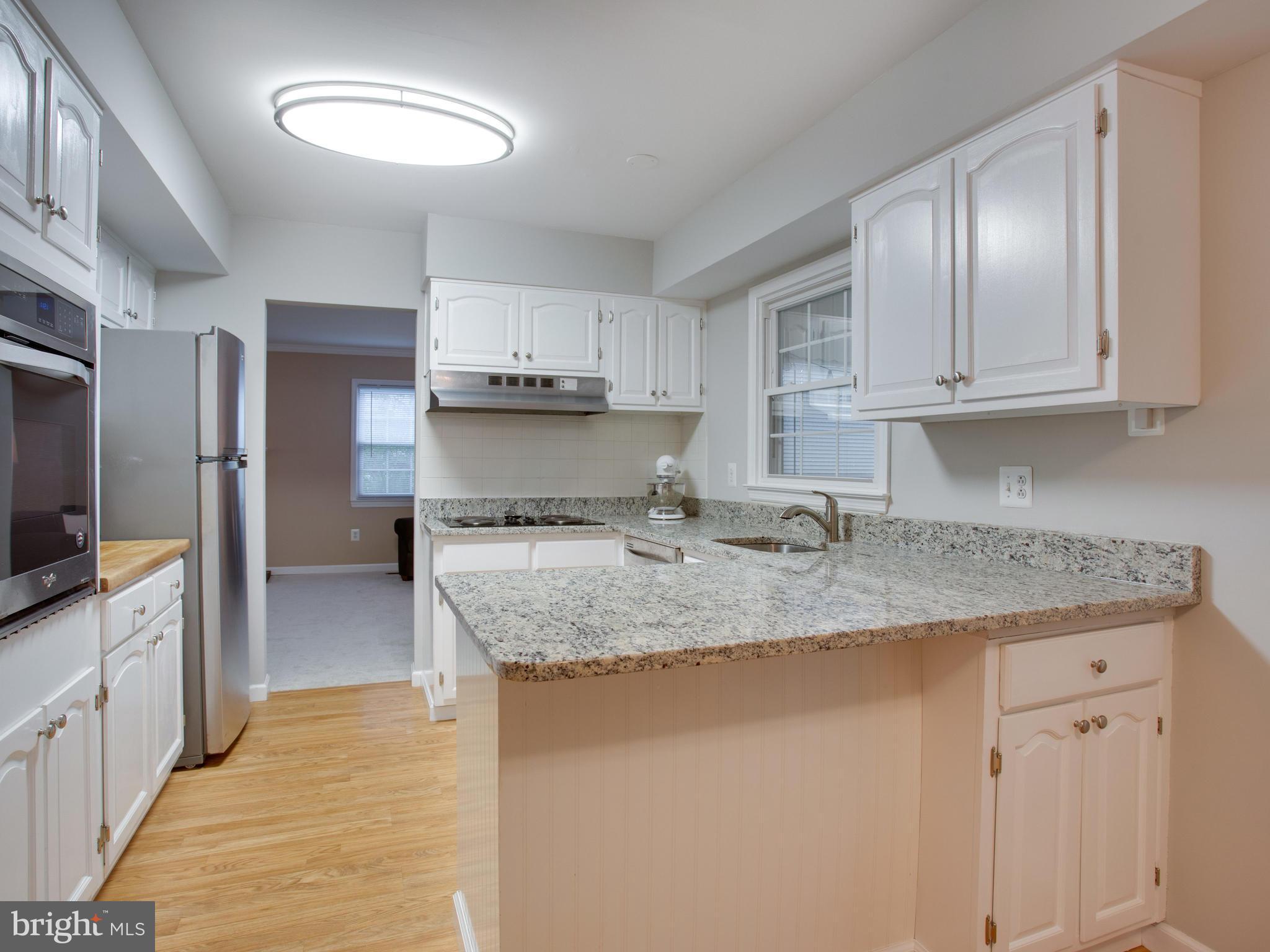 13132 Moss Ranch Lane Fairfax, VA 22033 - Photo 11 of 30 a kitchen with stainless steel appliances granite countertop a sink stove and refrigerator
