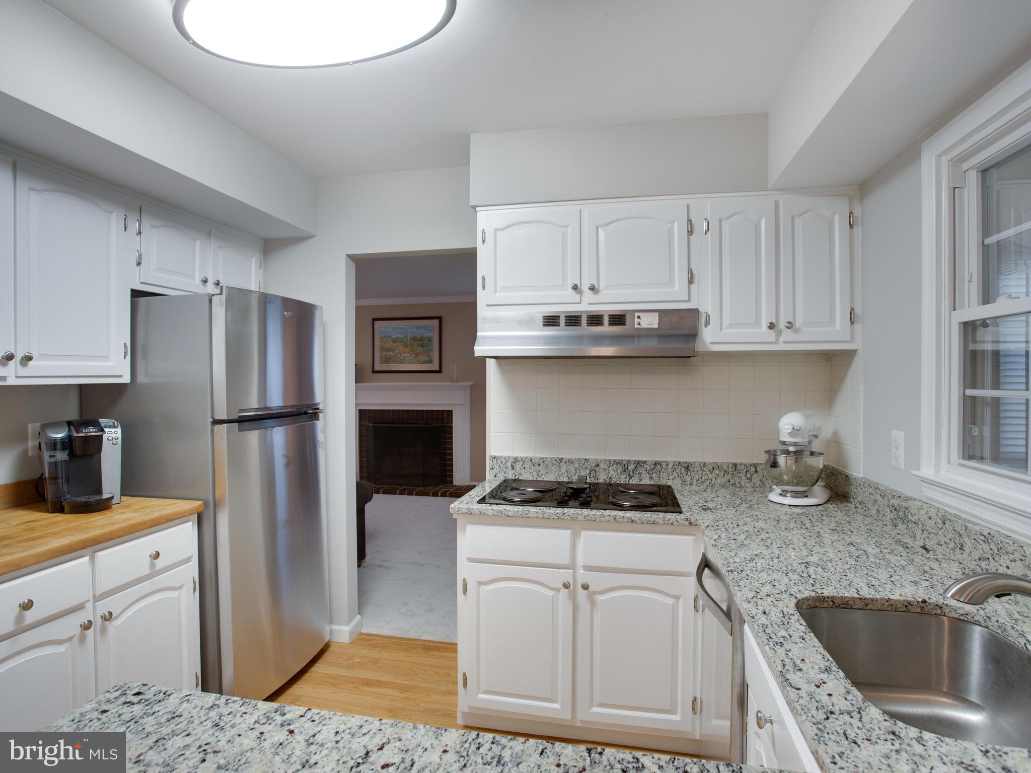13132 Moss Ranch Lane Fairfax, VA 22033 - Photo 10 of 30 a kitchen with white cabinets and stainless steel appliances
