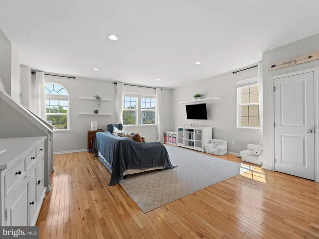 a spacious bedroom with a bed and a flat screen tv