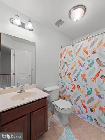 a bathroom with a sink a toilet and shower curtain