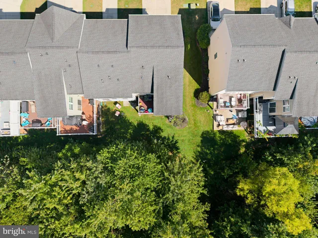 an aerial view of a house with swimming pool and large trees