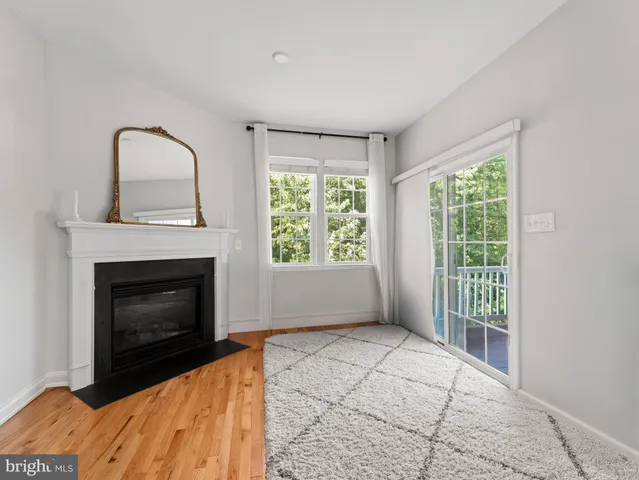 a view of an empty room with a fireplace and a window