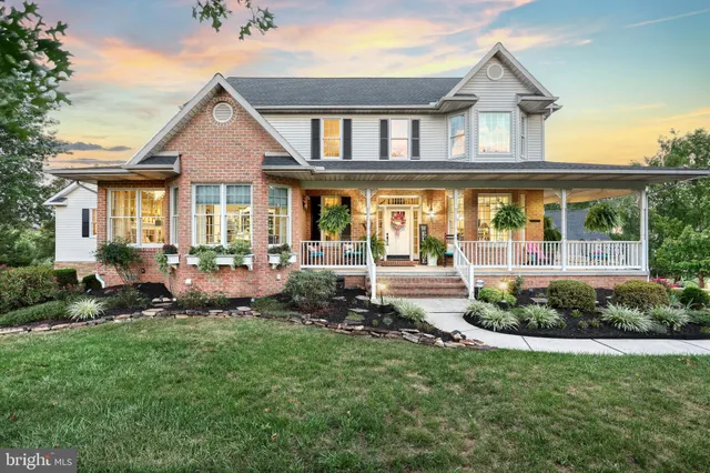 a front view of a house with a yard and potted plants
