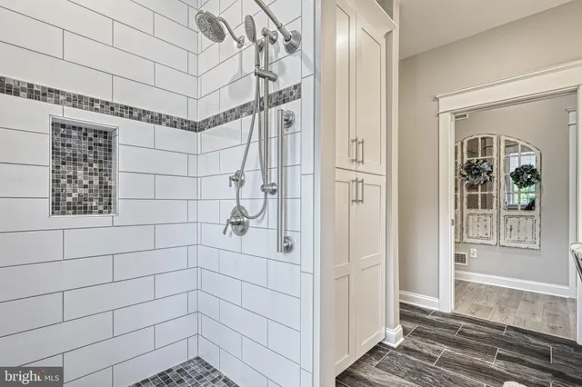 a bedroom with a bed a mirror and a large window