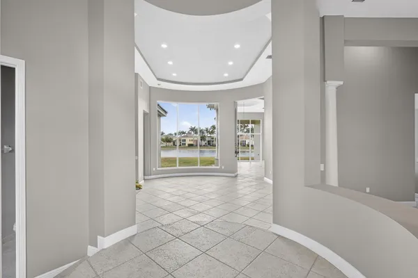 a view of a hallway with wooden floor and a living room