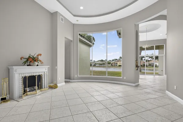 a view of an empty room with glass door and fire place
