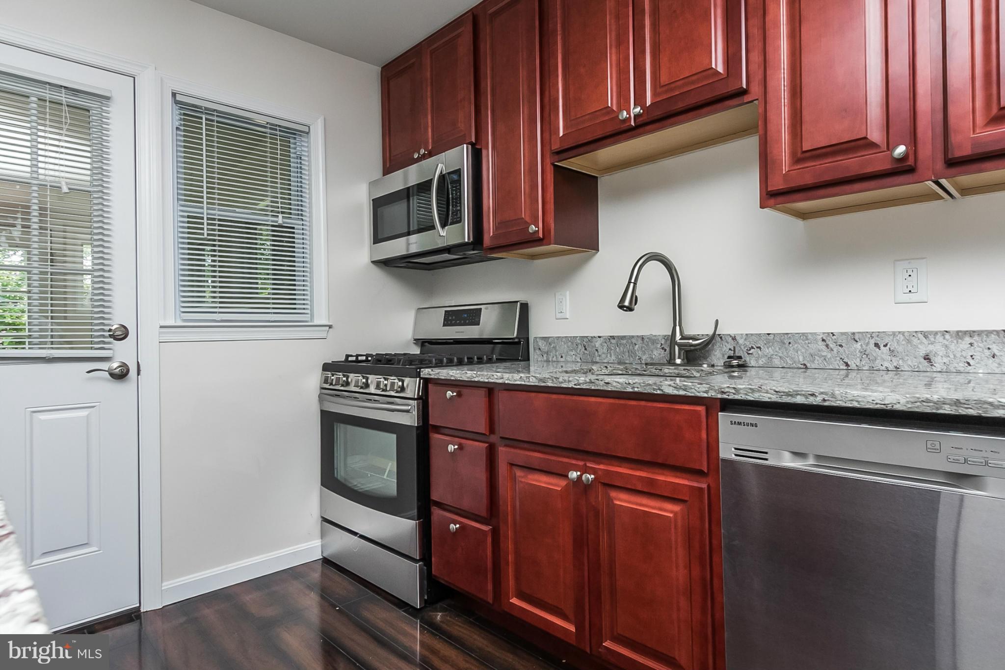 16 Bladen Road Baltimore, MD 21221 - Photo 11 of 29 a kitchen with stainless steel appliances granite countertop a stove a sink and dishwasher with wooden cabinets