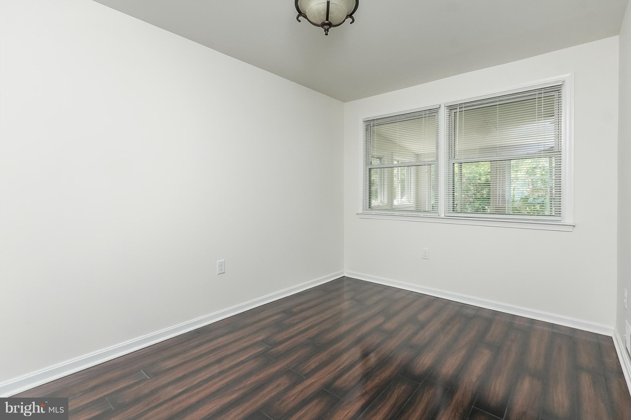 16 Bladen Road Baltimore, MD 21221 - Photo 7 of 29 a view of an empty room with wooden floor and a window