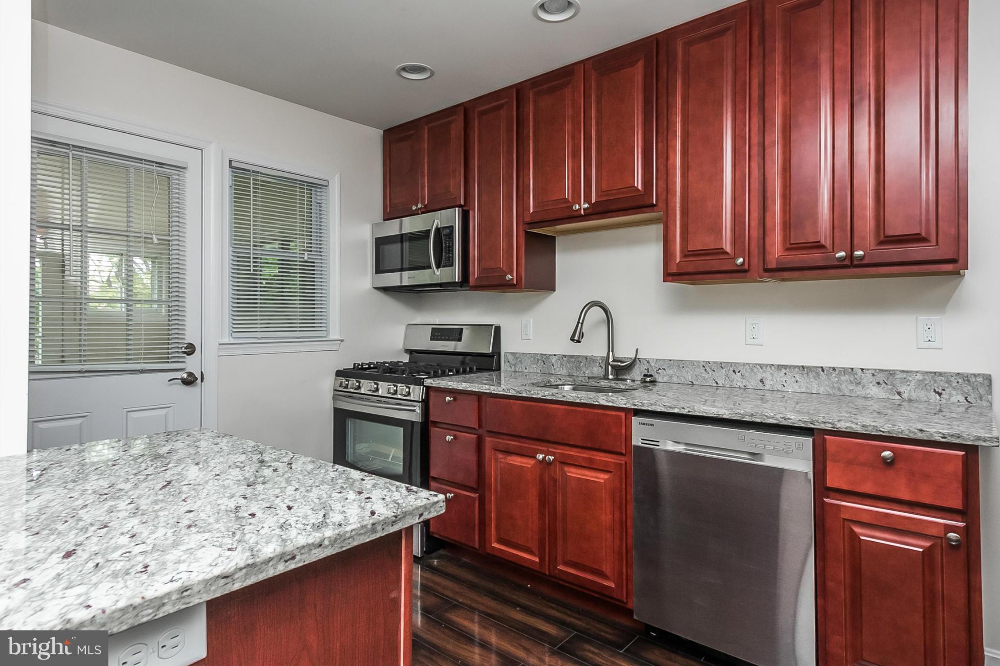 16 Bladen Road Baltimore, MD 21221 - Photo 9 of 29 a kitchen with kitchen island granite countertop wooden cabinets a sink and dishwasher