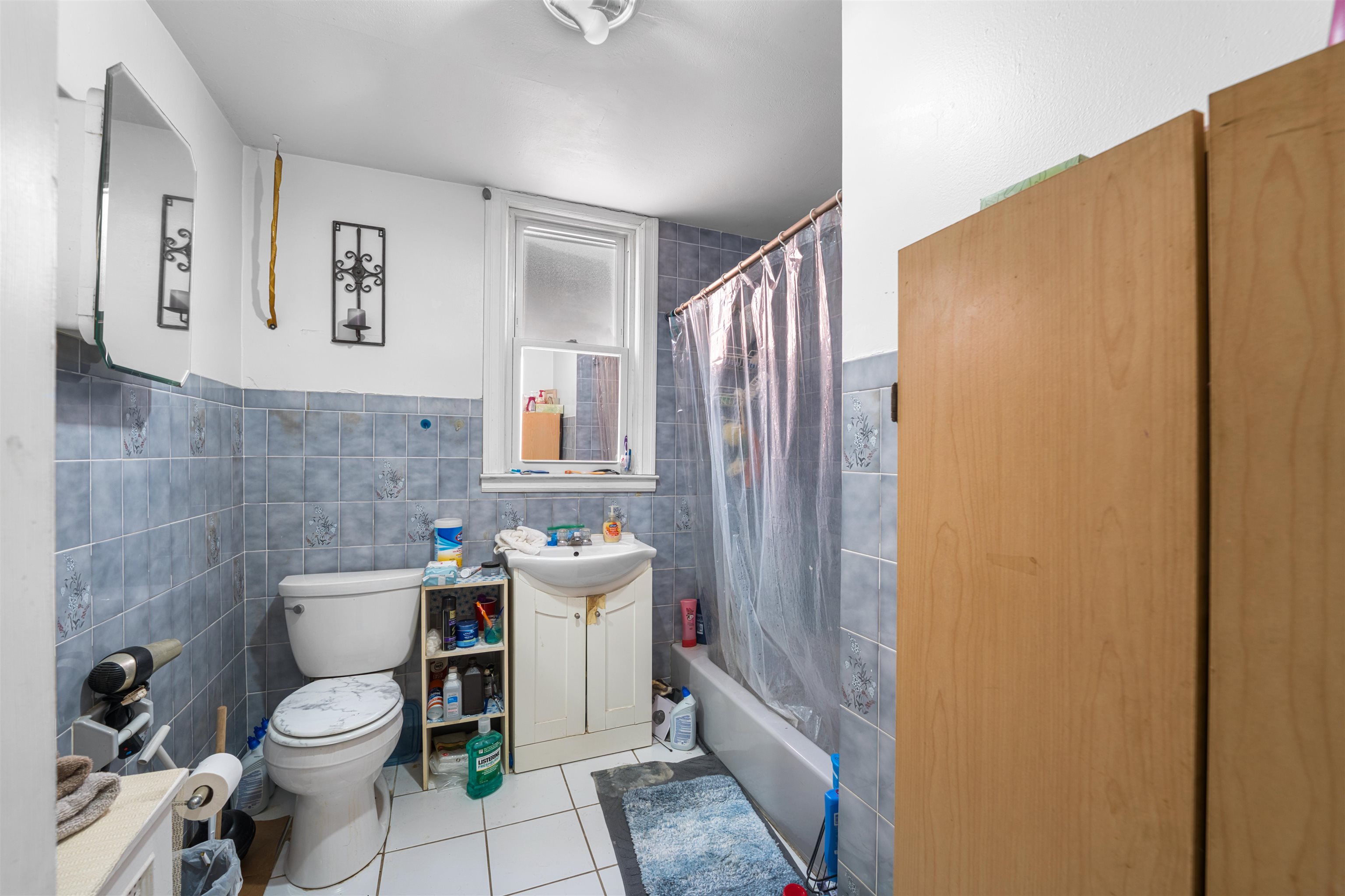 154 West 33rd Street Bayonne, NJ 07002 - Photo 18 of 40 a bathroom with a sink a toilet and shower curtain