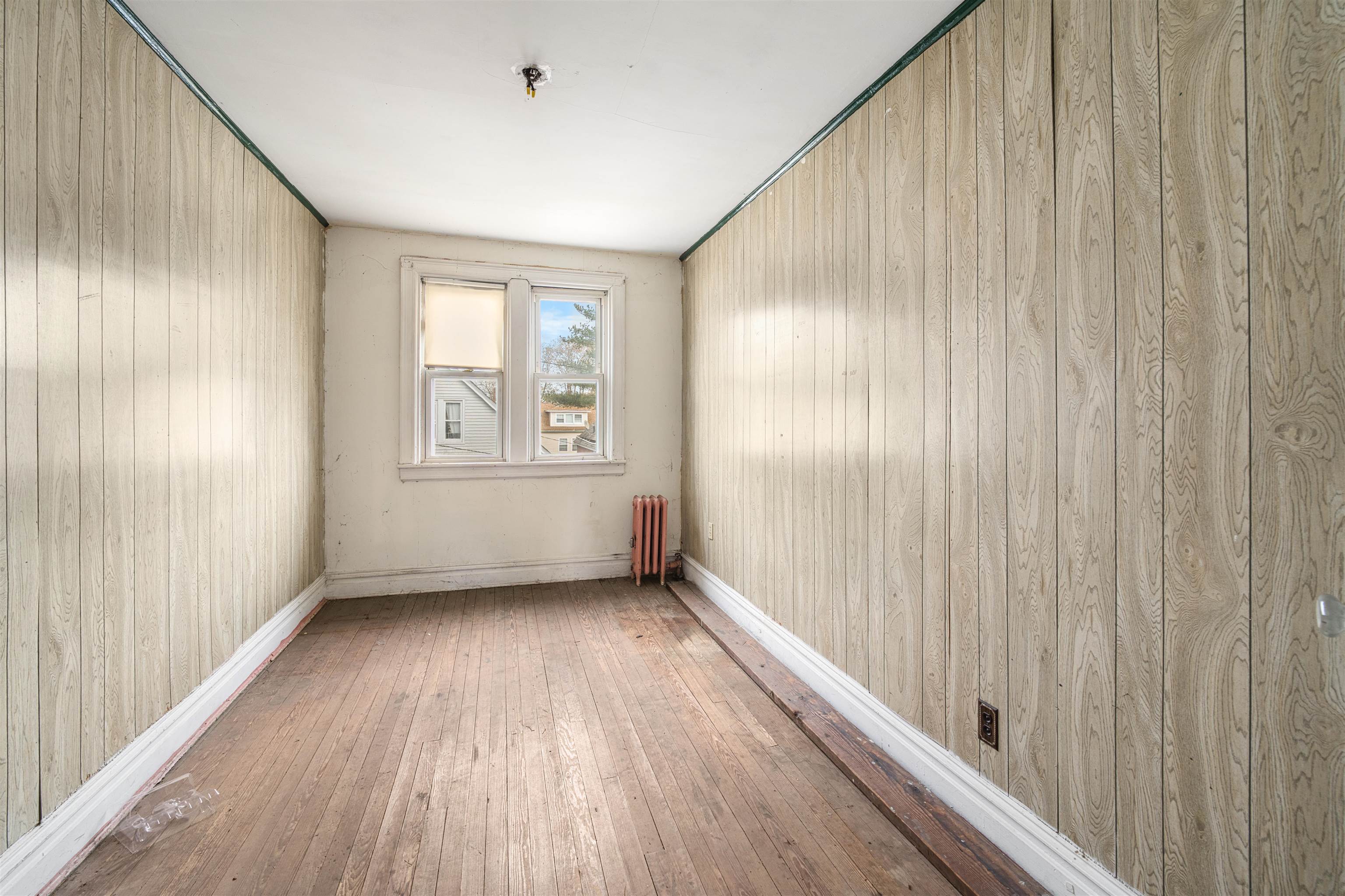 154 West 33rd Street Bayonne, NJ 07002 - Photo 7 of 40 a view of an empty room with wooden floor and a window