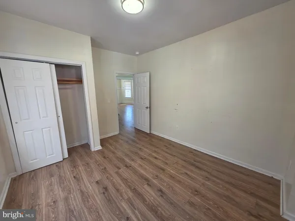 an empty room with wooden floor and closet