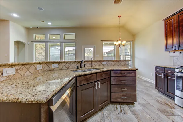 a bathroom with a granite countertop sink a large mirror and a window
