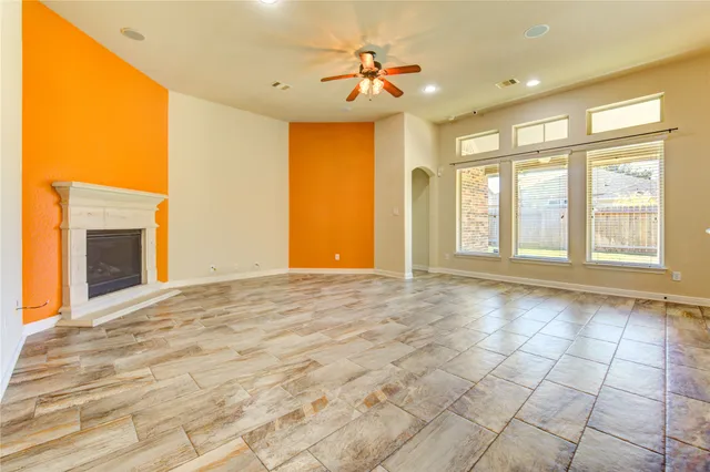 a view of an empty room with a fireplace and a window
