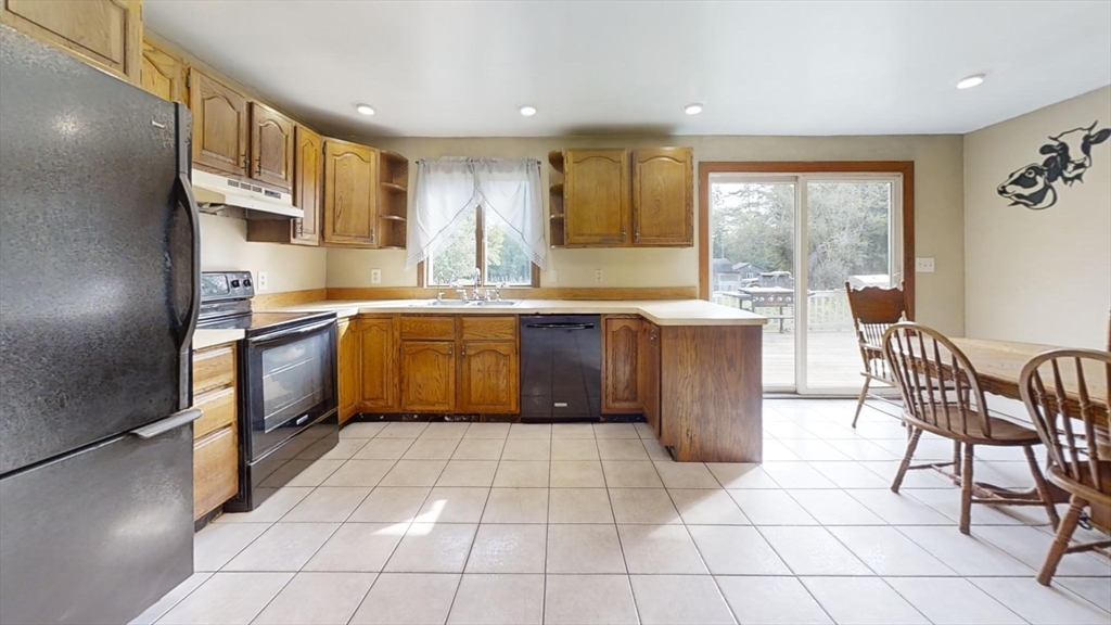 924 Walnut Plain Road Rochester, MA 02770 - Photo 13 of 36 a kitchen with stainless steel appliances granite countertop a table chairs sink and cabinets