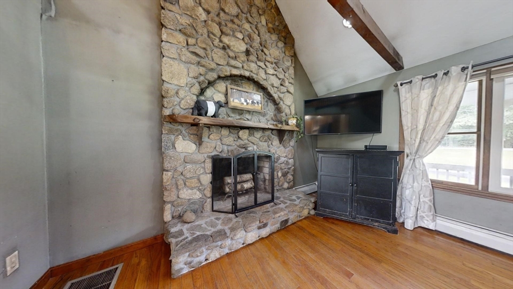 924 Walnut Plain Road Rochester, MA 02770 - Photo 7 of 36 a living room with furniture a flat screen tv and a fireplace