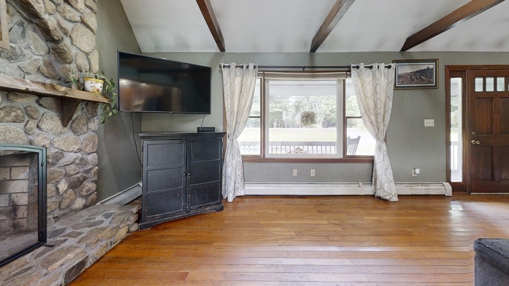 924 Walnut Plain Road Rochester, MA 02770 - Photo 8 of 36 a living room with a wooden floor and a flat screen tv