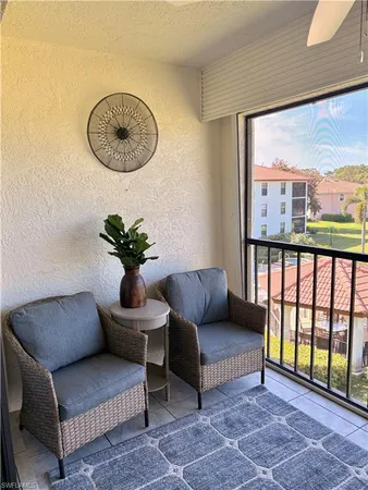 a living room with furniture and a floor to ceiling window
