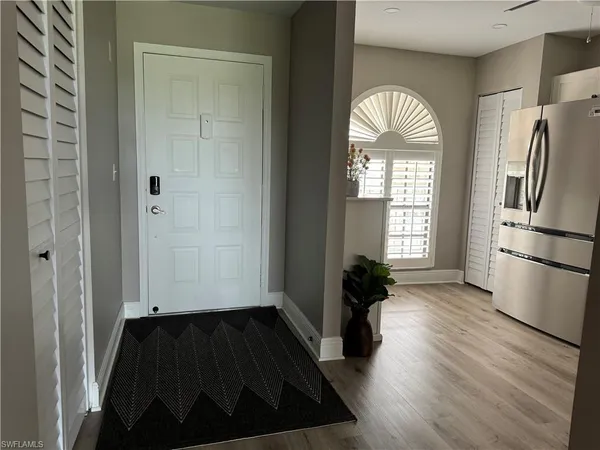 a view of a entryway door wooden floor and a living room