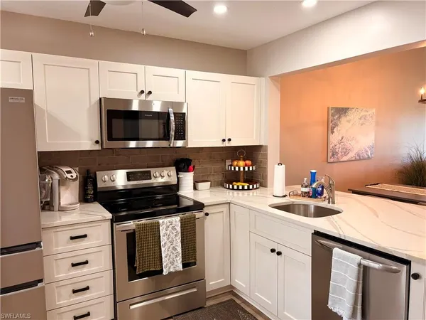 a kitchen with stainless steel appliances a stove microwave and sink