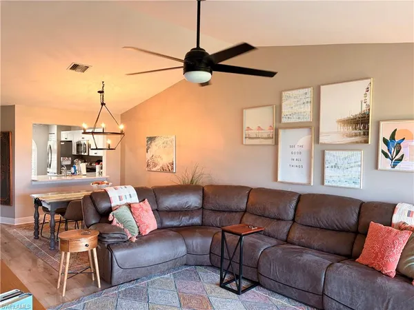 a living room with furniture a ceiling fan and a window