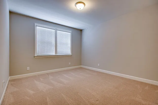 an empty room with windows and mirror