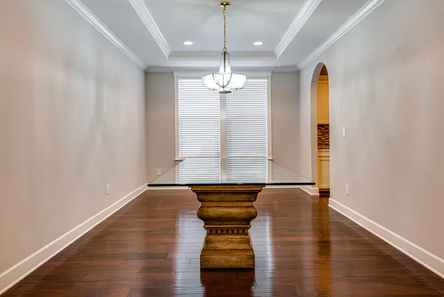 a hallway with a chandelier and wooden floor