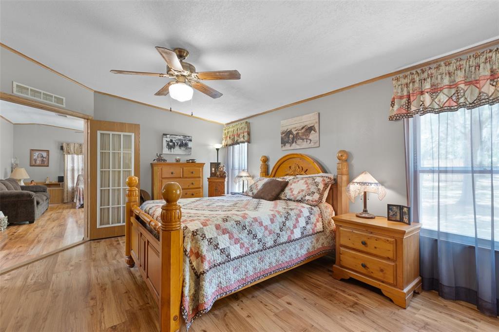 6689 Southeast 55th Street Trenton, FL 32693 - Photo 19 of 83 a bedroom with a bed and wooden floor