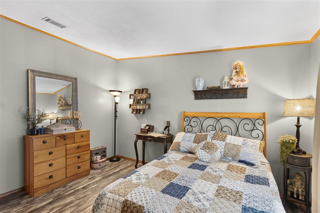 6689 Southeast 55th Street Trenton, FL 32693 - Photo 36 of 83 a bedroom with a bed and wooden floor