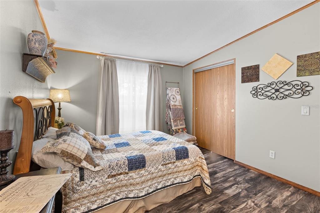 6689 Southeast 55th Street Trenton, FL 32693 - Photo 38 of 83 a bedroom with a bed and wooden floor