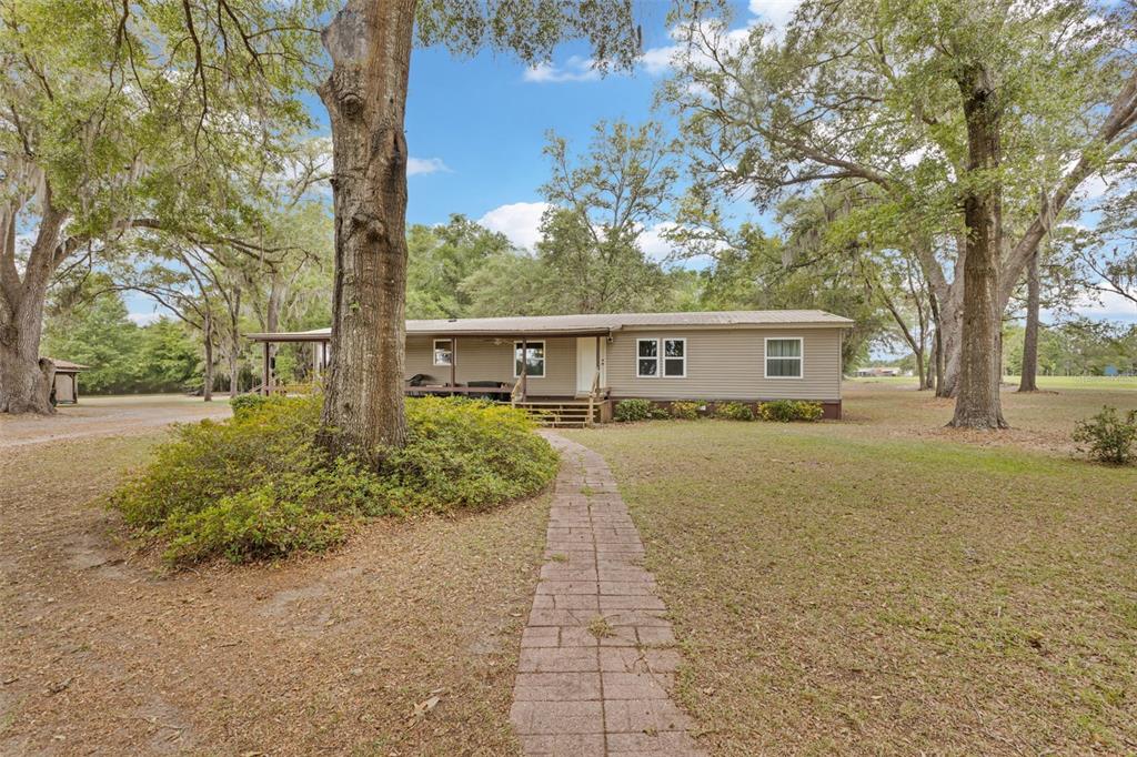 6689 Southeast 55th Street Trenton, FL 32693 - Photo 68 of 83 a view of house with outdoor space and trees in the background